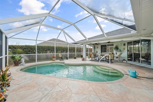 view of pool featuring ceiling fan, glass enclosure, and a patio area