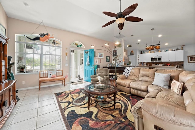 living room with ceiling fan, light tile patterned floors, and lofted ceiling