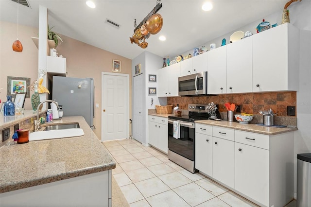 kitchen with white cabinets, appliances with stainless steel finishes, sink, and tasteful backsplash