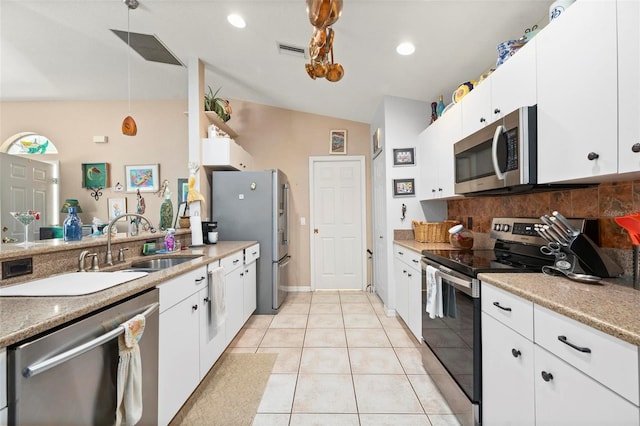 kitchen featuring light tile patterned floors, white cabinetry, appliances with stainless steel finishes, backsplash, and sink