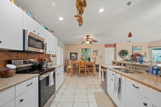 kitchen featuring ceiling fan, appliances with stainless steel finishes, decorative light fixtures, white cabinets, and sink