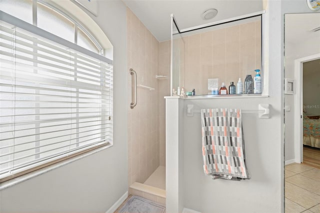 bathroom with tile patterned flooring and tiled shower