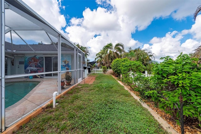 view of yard with a patio area and glass enclosure