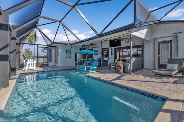 view of pool featuring glass enclosure, ceiling fan, and a patio area