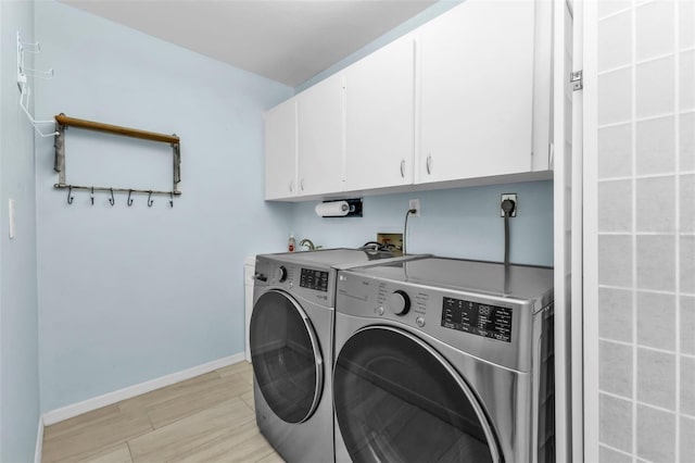 laundry room with cabinets, separate washer and dryer, and light hardwood / wood-style floors