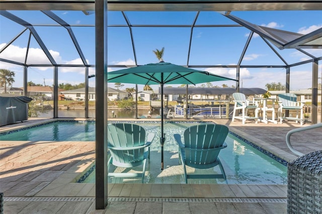 view of swimming pool with a patio, a water view, area for grilling, and a lanai