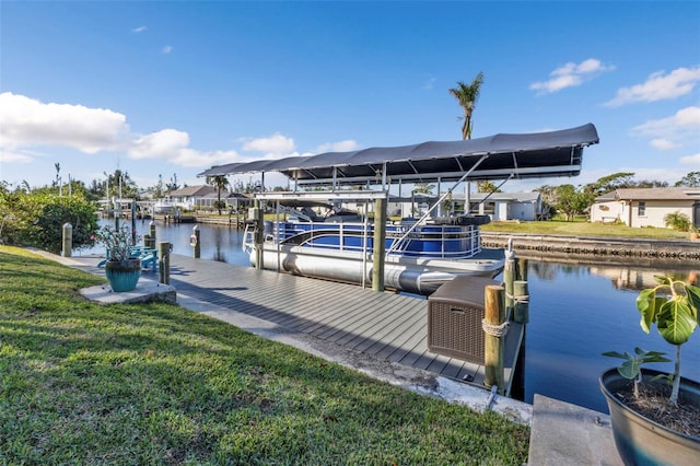 view of dock with a yard and a water view