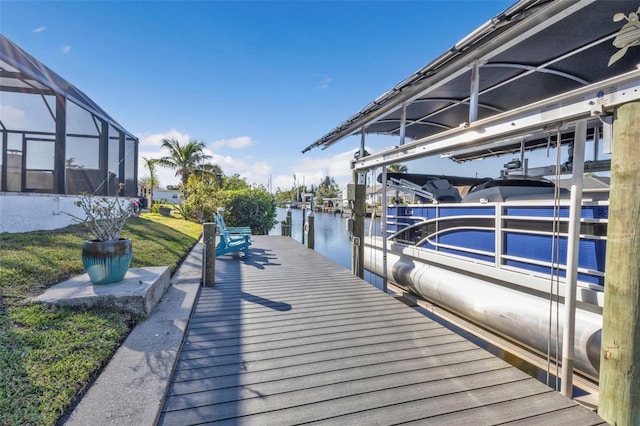 dock area featuring a yard, a water view, and a lanai