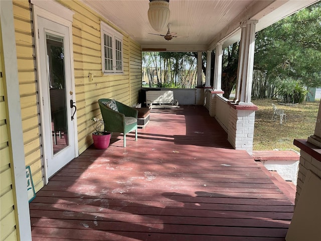 wooden deck featuring covered porch and ceiling fan