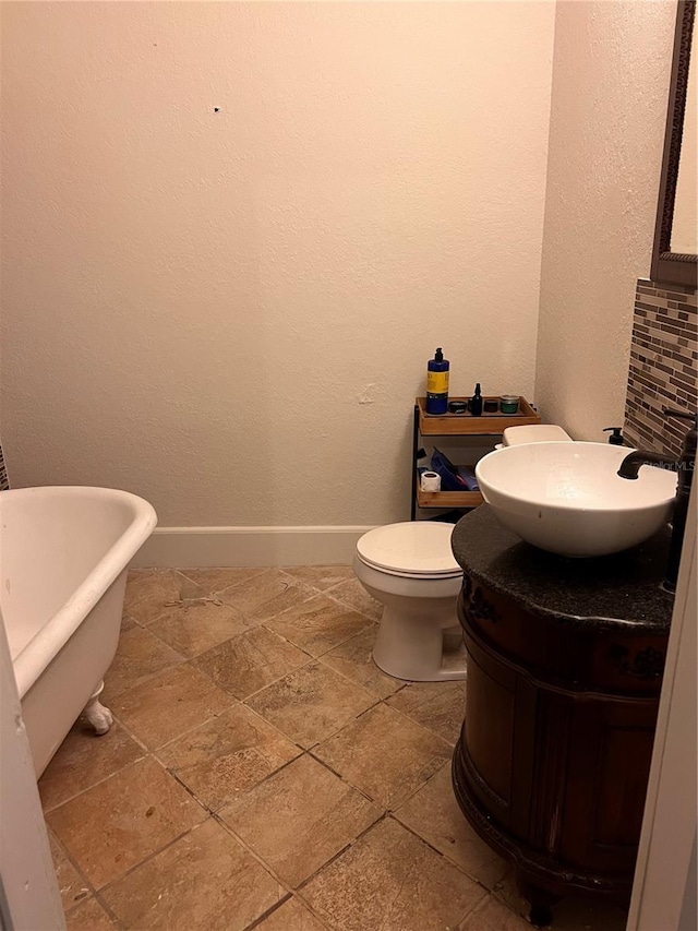 bathroom with vanity, toilet, and a tub