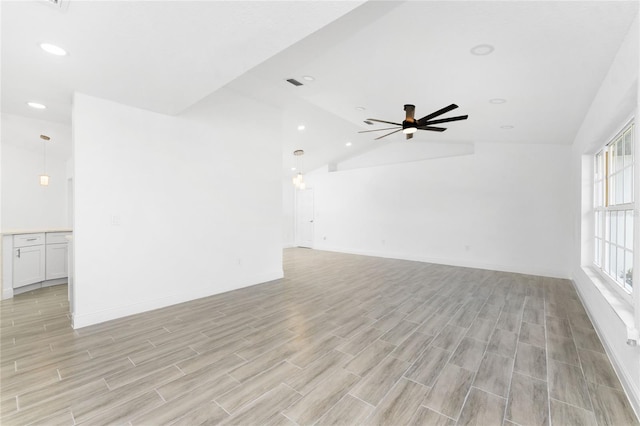 spare room with light hardwood / wood-style flooring, vaulted ceiling, and ceiling fan