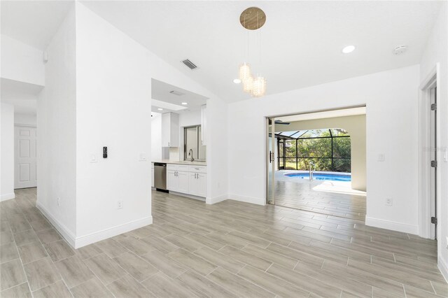 interior space with sink, lofted ceiling, and light hardwood / wood-style floors