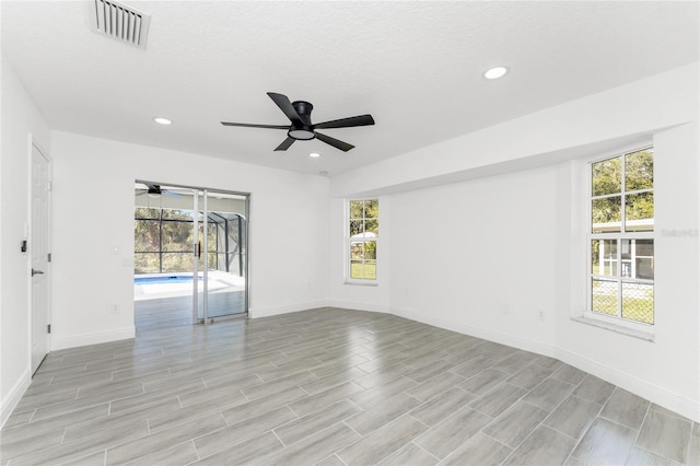 unfurnished room with light hardwood / wood-style flooring, ceiling fan, and a textured ceiling