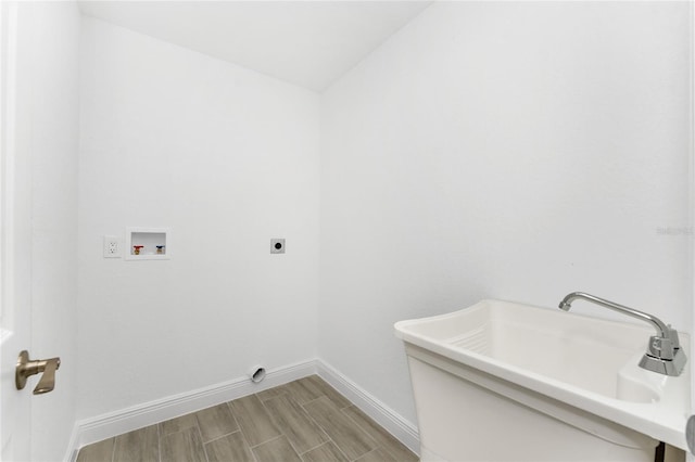 washroom featuring sink, light hardwood / wood-style flooring, washer hookup, and hookup for an electric dryer