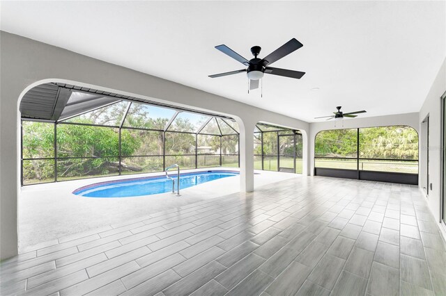 view of swimming pool featuring a patio and glass enclosure