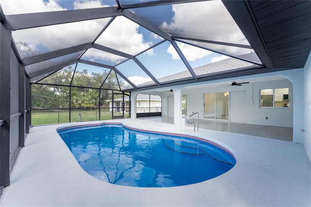 view of swimming pool featuring glass enclosure, ceiling fan, and a patio area