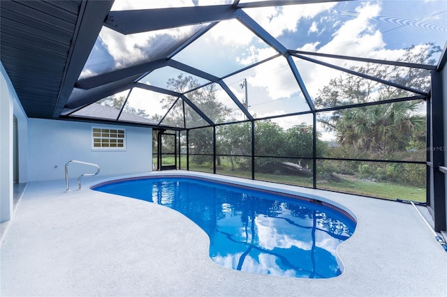 view of swimming pool featuring glass enclosure and a patio area