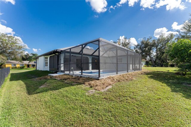 rear view of house featuring a yard and a lanai