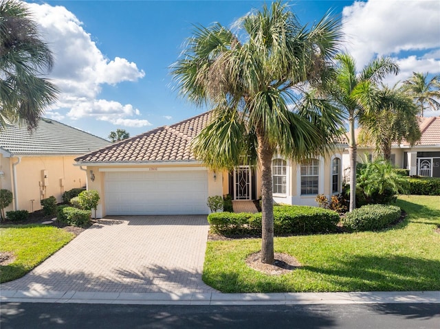 mediterranean / spanish home with a garage and a front lawn