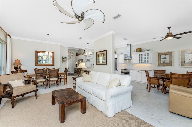 tiled living room with ceiling fan with notable chandelier and ornamental molding