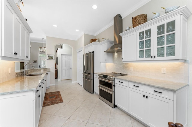 kitchen featuring white cabinets, stainless steel appliances, wall chimney exhaust hood, and sink