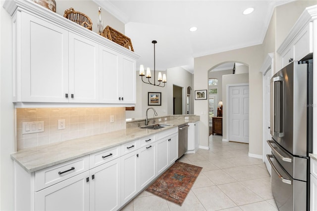 kitchen with white cabinets, sink, tasteful backsplash, light stone counters, and stainless steel appliances