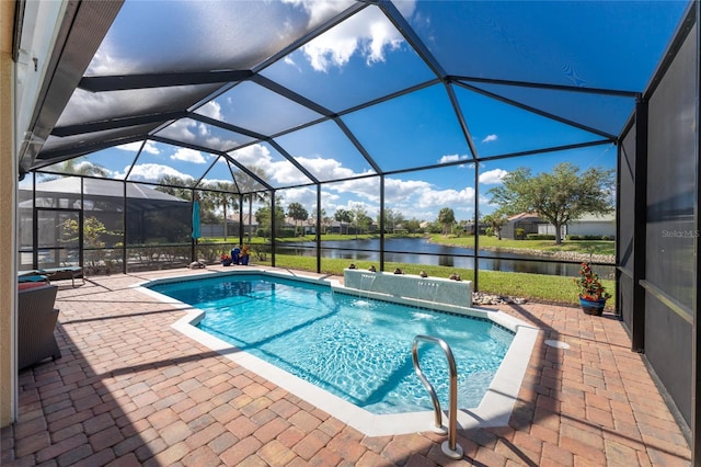 view of swimming pool with pool water feature, glass enclosure, a patio area, and a water view