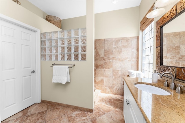 bathroom with vanity, tile walls, and walk in shower