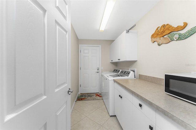 washroom with cabinets, light tile patterned floors, and separate washer and dryer