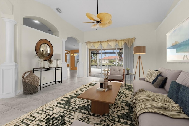 living room featuring ceiling fan, light tile patterned flooring, ornate columns, and lofted ceiling