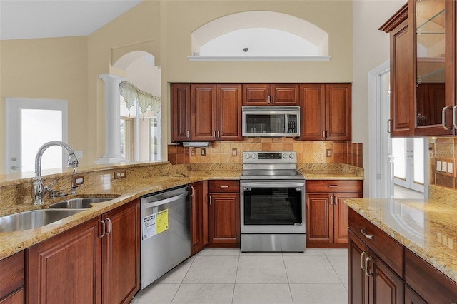 15460 Longview Rd, Port Charlotte, FL 33981 - kitchen featuring stainless steel appliances, a sink, ornate columns, plenty of natural light, and a high ceiling