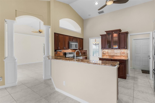 15460 Longview Rd, Port Charlotte, FL 33981 - kitchen with ceiling fan, appliances with stainless steel finishes, high vaulted ceiling, ornate columns, and backsplash