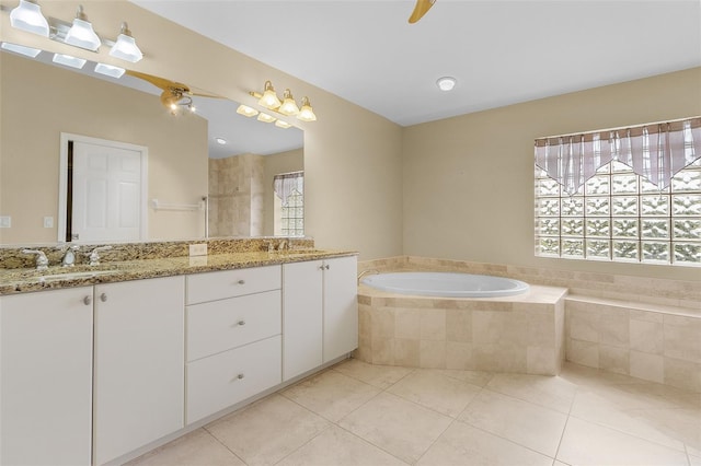 bathroom featuring tile patterned floors, vanity, and tiled tub