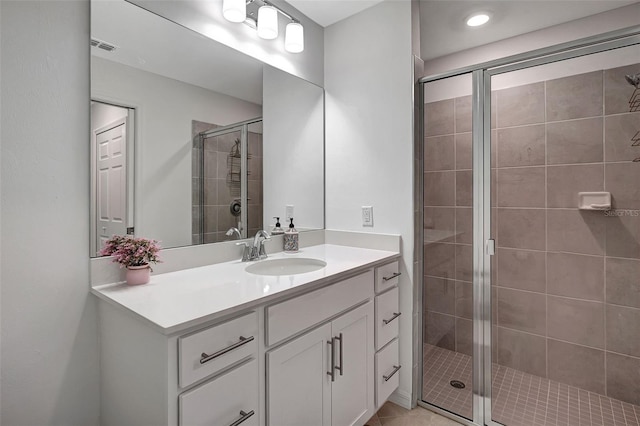 bathroom featuring tile patterned flooring, vanity, and a shower with shower door