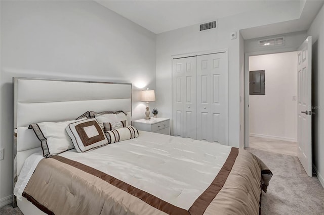 bedroom with electric panel, light carpet, and a closet