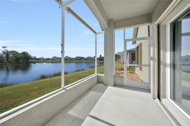 sunroom featuring a water view