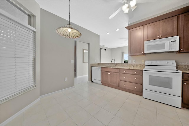 kitchen featuring hanging light fixtures, sink, ceiling fan, light stone countertops, and white appliances