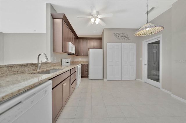 kitchen featuring sink, light stone counters, ceiling fan, hanging light fixtures, and white appliances