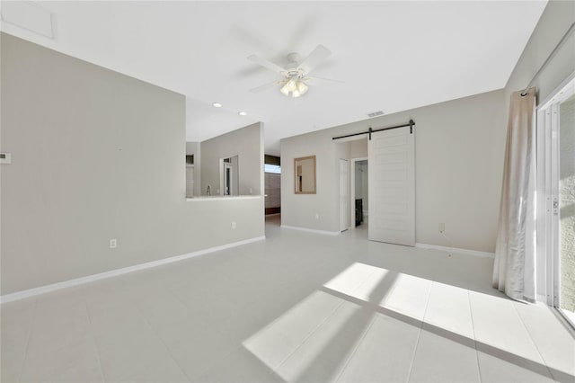 tiled empty room with a barn door and ceiling fan