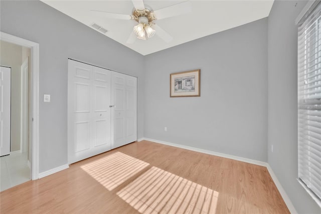 unfurnished bedroom featuring light hardwood / wood-style floors, ceiling fan, and a closet