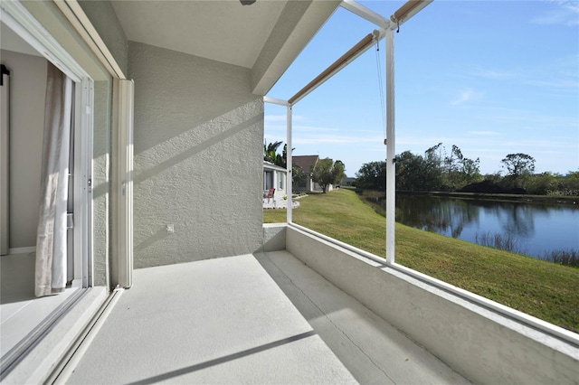 sunroom featuring a water view