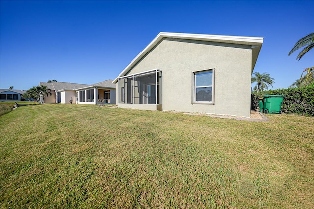 rear view of property featuring a sunroom and a yard