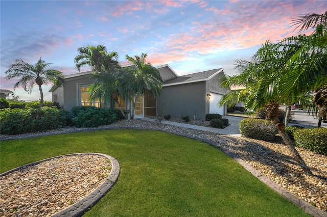 view of front of home featuring a lawn and a garage