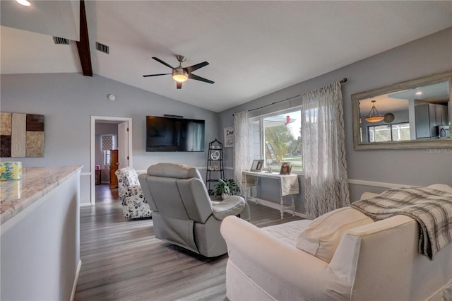 living room featuring vaulted ceiling with beams, ceiling fan, and hardwood / wood-style flooring