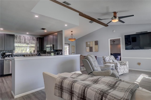 living room featuring lofted ceiling with beams, dark hardwood / wood-style floors, and ceiling fan