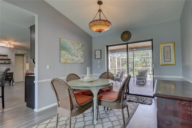 dining space featuring hardwood / wood-style floors and lofted ceiling