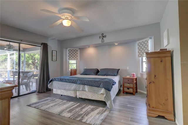 bedroom with hardwood / wood-style floors, a textured ceiling, access to outside, and ceiling fan