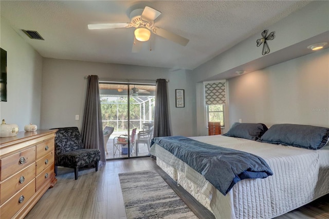 bedroom featuring multiple windows, access to outside, light hardwood / wood-style flooring, and ceiling fan