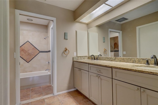 bathroom with tile patterned floors, vanity, and tiled shower / bath combo