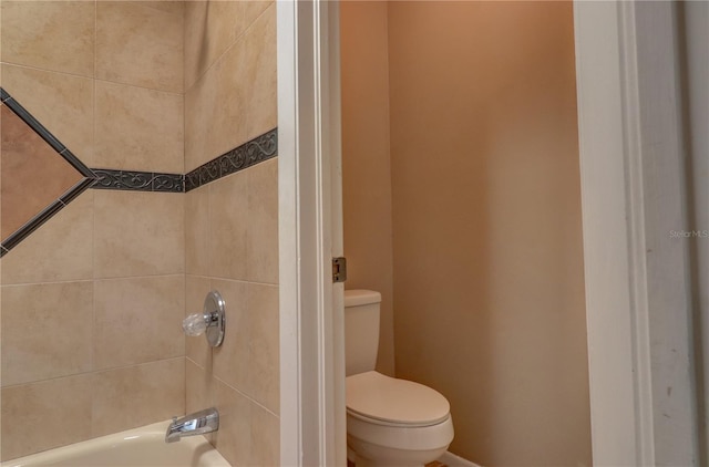 bathroom with tiled shower / bath combo and toilet